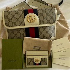 This Is An Authentic Gucci Gg Supreme Monogram Web Small Ophidia Belt Bag Beige, Ebony, And White. This Chic Belt Bag Is Finely Crafted Of Gucci Gg Monogram Coated Canvas. The Bag Features A Navy Blue And Red Web Stripe Fabric Detail, With Leather Trim, And Aged Gold Hardware. The Front Flap Opens With A Magnetic Closure To A Beige Fabric Interior. Comes With Dust Bag For Both Bag & Card Holder As Well As A Box For The Cardholder Size For Belt Bag: Base Length: 9.5 In Height: 6.5 In Width: 1 In Longest Length: 37.5 In Wore Only Twice - In Perfect Condition This Purchase Is For The Belt Bag & Card Holder Ophidia Belt Bag, Chic Belt, Red Web, Gg Monogram, Stripe Fabric, Beige Fabric, Striped Fabrics, Gucci Bags, Leather Trim