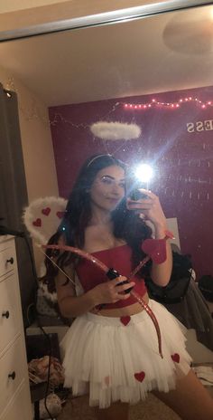 a woman taking a selfie in front of a mirror wearing a santa claus costume