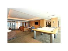 a living room with a pool table and couches next to a flat screen tv