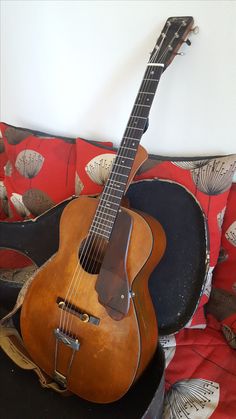 an old guitar sitting on top of a chair