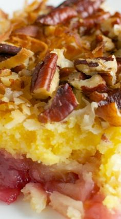 a close up of a piece of cake on a plate with pecans and cranberry sauce