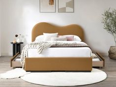 a bed that is sitting on top of a wooden floor next to a white rug