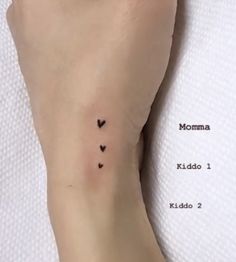 a small heart tattoo on the left side of the foot, with two smaller hearts in it