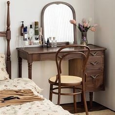 a bedroom scene with focus on the vanity and bed, along with an antique mirror