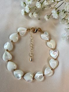 Shell Heart Beaded Bracelet | 18k Gold clasp & Extender Chain | 6-inch Adjustable Add a touch of coastal elegance to your look with this beautiful shell heart beaded bracelet. Featuring delicate beads and a charming shell heart centerpiece, this bracelet combines natural beauty with modern design. The 6-inch bracelet includes a convenient extender chain, ensuring a perfect, adjustable fit for any wrist size. This bracelet is versatile enough to pair with any outfit, offering a chic accent whether you're dressing up or keeping it casual. The gold-plated charm and hardware add a luxurious feel, while the shell heart brings a unique, organic element to your jewelry collection. Why you'll love it: *Adjustable Fit: The extender chain allows you to customize the fit, ensuring both comfort and st Shell Beads Jewelry, Shell Heart, Beach Bracelet, Coastal Elegance, Beach Bracelets, Shell Bracelet, Bracelet Beaded, Shell Beads, Heart Beads