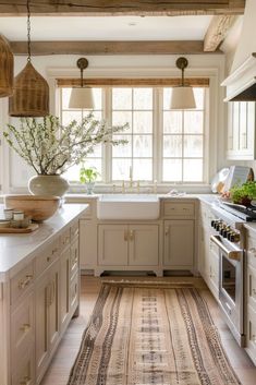 a kitchen with an area rug in front of the stove and sink, along with two windows