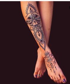 a woman's foot with an intricate tattoo design on her left arm and leg