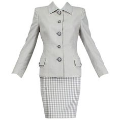 Demonstrating uncharacteristic restraint, Versace produced this demure suit that buttons to the throat near the end of his too-brief career. Its mini skirt length and iconic Medusa buttons are the only allusions to the designer's typically much bolder designs. Vintage pale gray-lavender and white micro-gingham suit jacket with heavily padded shoulders, pointed collar and working flap pockets each front hip; buttons to throat with 5 alternating-size carved Medusa buttons and finished buttonholes. Work Skirt Outfit, Fashion 1990s, Retro Suits, Skirt Suits, Gingham Skirt, Versace Couture, Vintage Versace, Vintage Clothes Women, Full Circle Skirts