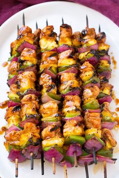 several skewers of food on a white plate