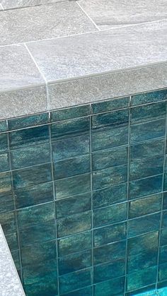 an empty swimming pool with blue tiles on the side