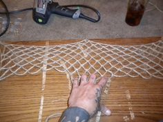 a person's foot on the floor next to a piece of string and wire