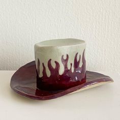 a white and red hat sitting on top of a wooden plate