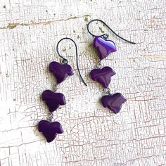 Leaves cascade in a triptych of deep purple moonglow in these epid drop earrings. Fun statement earrings are triple-linked made of light-weight vintage lucite. Drop earring measures just over 2.5" in length, and just under 1/2" at the widest width. Earwires are black metal & hypoallergenic.Light-weight & fun to wear. Earrings are made with vintage lucite parts that were made in Rhode Island in the 1960's - early 80's by Best Plastics. Cheap Purple Retro Earrings, Moon Glow, Vintage Lucite, Drop Earring, Rhode Island, Deep Purple, Black Metal, Statement Earrings, Drop Earrings