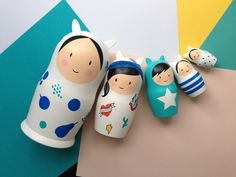 three wooden dolls are lined up next to each other on a table with colorful background