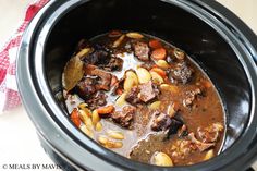 a slow cooker filled with meat and vegetables