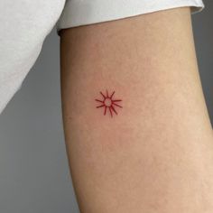 a small red tattoo on the back of a woman's leg