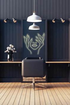 a black chair sitting on top of a wooden floor next to a table with flowers