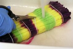 a person cutting corn with a pair of scissors on top of it in a sink