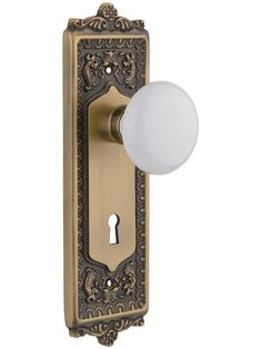 an ornate door handle with a white ball on it