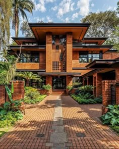 a large brick house surrounded by trees and plants