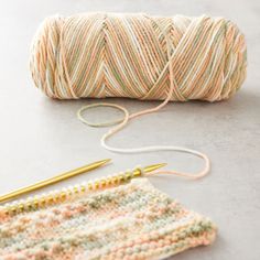 two skeins of yarn next to a crochet hook