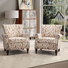 a living room with two chairs and a rug on the floor in front of a window