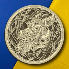 an intricately designed metal medallion on a yellow and blue background with the dragon symbol