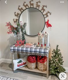 a decorated entryway with christmas decorations and gifts on the table next to a mirror