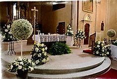 the altar is decorated with white flowers and greenery for a wedding or special occasion