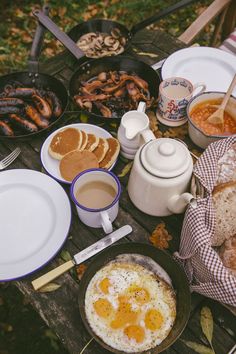 an assortment of breakfast foods are laid out on a picnic table