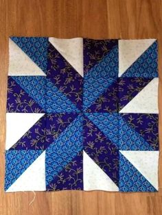 a blue and white patchwork quilt on top of a wooden floor