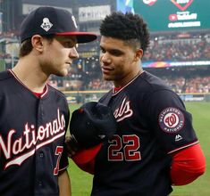 two baseball players standing next to each other in front of a stadium full of people