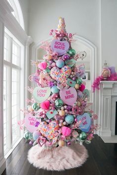 a pink christmas tree decorated with heart shaped balloons