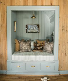 a room that has some pillows on the couch and other items in it with wood paneling