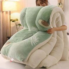 a woman is holding a stuffed animal in the shape of a turtle on top of a bed