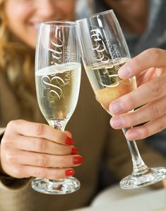 two people holding up wine glasses in their hands