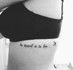 a woman with a tattoo on her stomach that says, to travel is to live