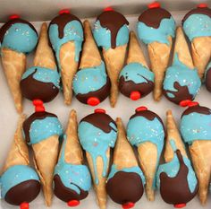 chocolate covered ice cream cones with blue icing and sprinkles on them