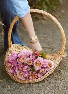 a person holding a basket with flowers in it