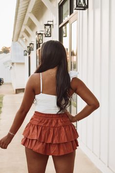 Rusty Brown faux leather tiered ruffle skirt featuring a drawstring tie waistband and built in shorts! Skirt is a petite fit! 45% PU, 55% polyester Model is 5'4" wearing a small. Day Out Tiered Ruffle Shorts, Ruffled Tiered Skort For Day Out, Tiered Skort For Day Out, Flirty Tiered Skort For Day Out, Tiered Ruffle Hem Shorts For Day Out, Brown Ruffled Mini Skirt For Summer, Brown Tiered Ruffle Skirt, Brown Tiered Mini Skirt For Summer, Brown Tiered Mini Skirt For Spring