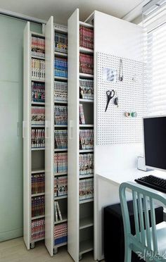 a computer desk sitting next to a book shelf