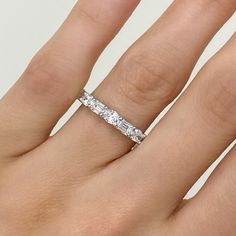 a woman's hand with a diamond ring on top of her finger and the band is in white gold