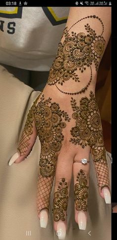 a woman's hand with henna tattoos on it, and the image is taken from