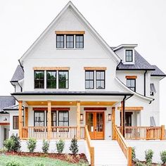 a large white house with two story windows and wooden steps leading to the front door