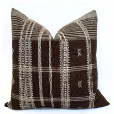 a brown and white plaid pillow on a white background