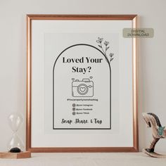 a framed poster with the words loved your stay? and an image of a camera