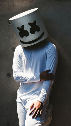 a person wearing a white shirt and hat with a smiley face on it's head