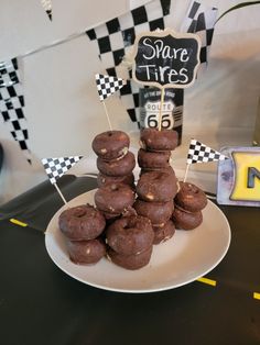 a white plate topped with chocolate donuts on top of a black and yellow table