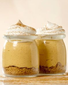 two jars filled with dessert sitting on top of a table