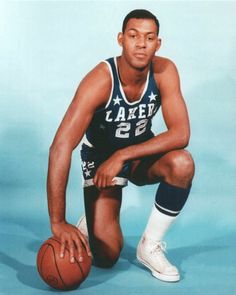 a man kneeling down with a basketball in his hand